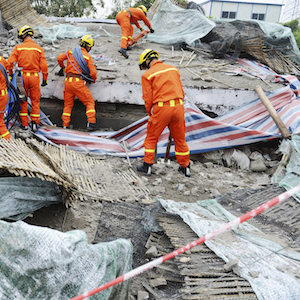 3.disaster relief workers orange suit on rubble