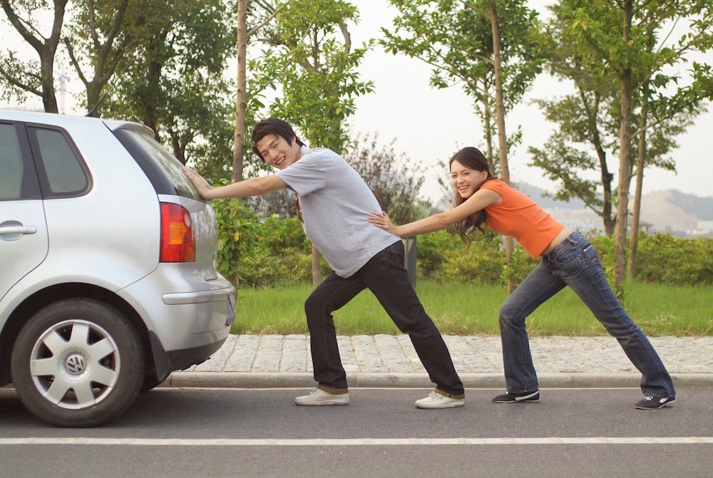 Couple pushing car